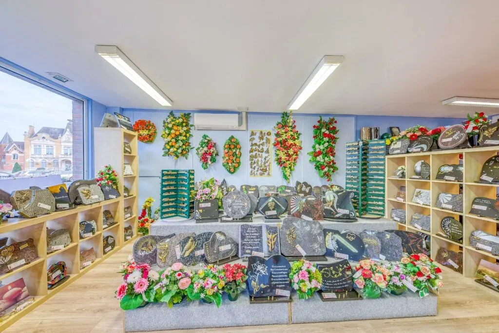 Intérieur d'un magasin funéraire présentant des plaques et des fleurs.